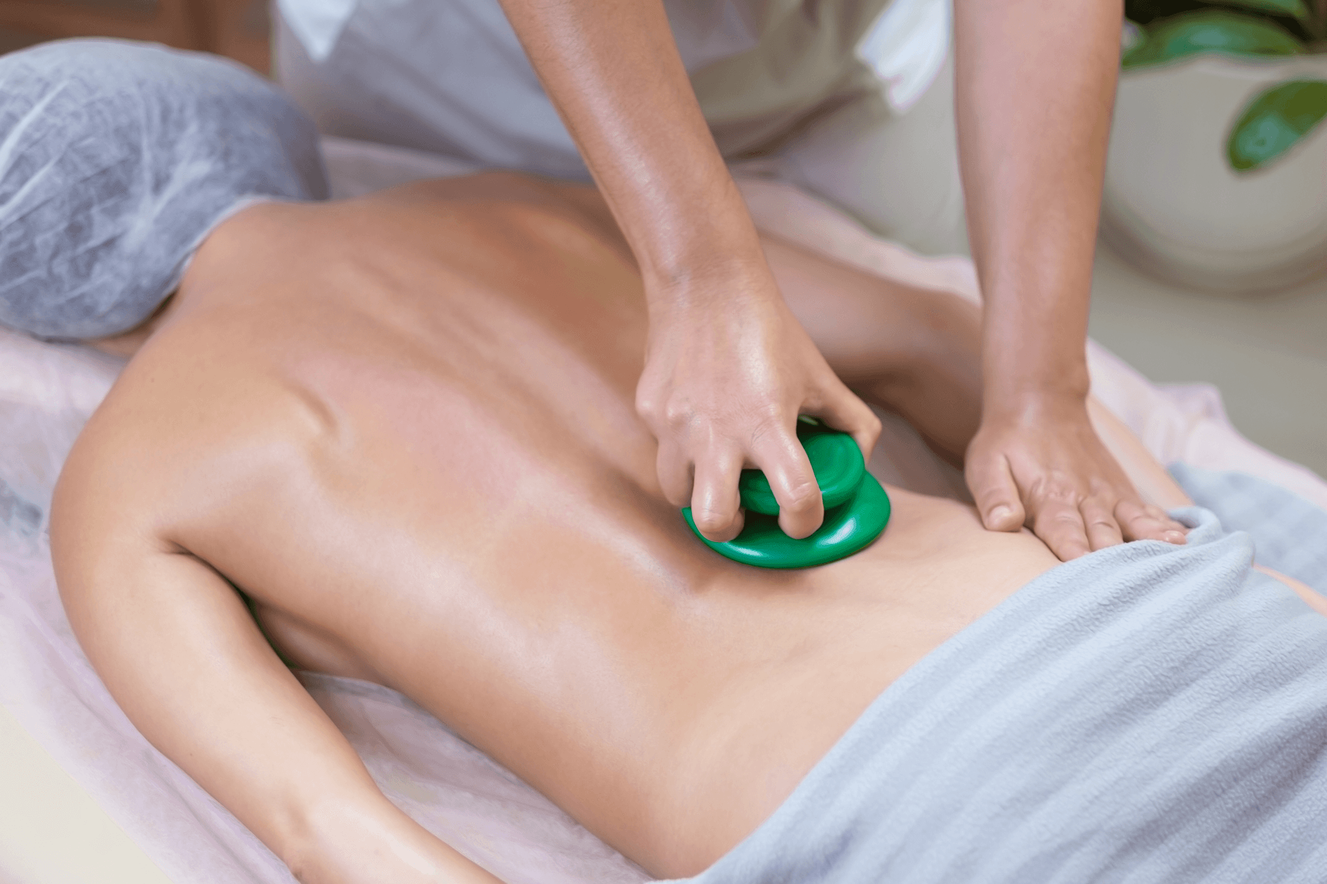 Frau bekommt Massage mit grüner Wärmepackung