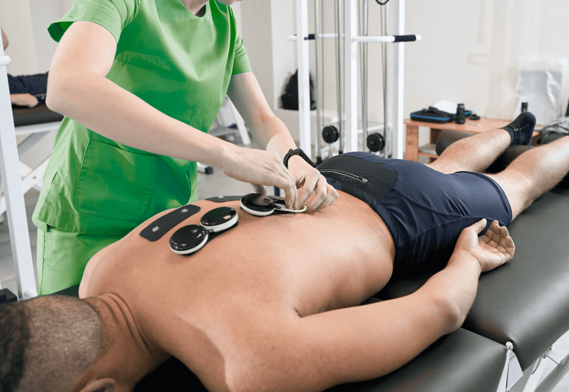 Mann bekommt Elektrotherapie von Dame in Grün